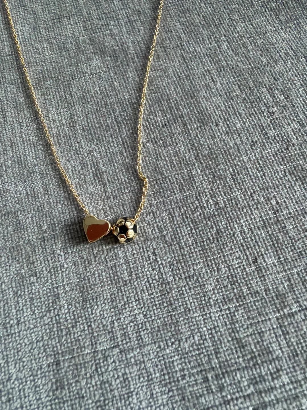 Gold tone necklace with heart and soccer ball charm