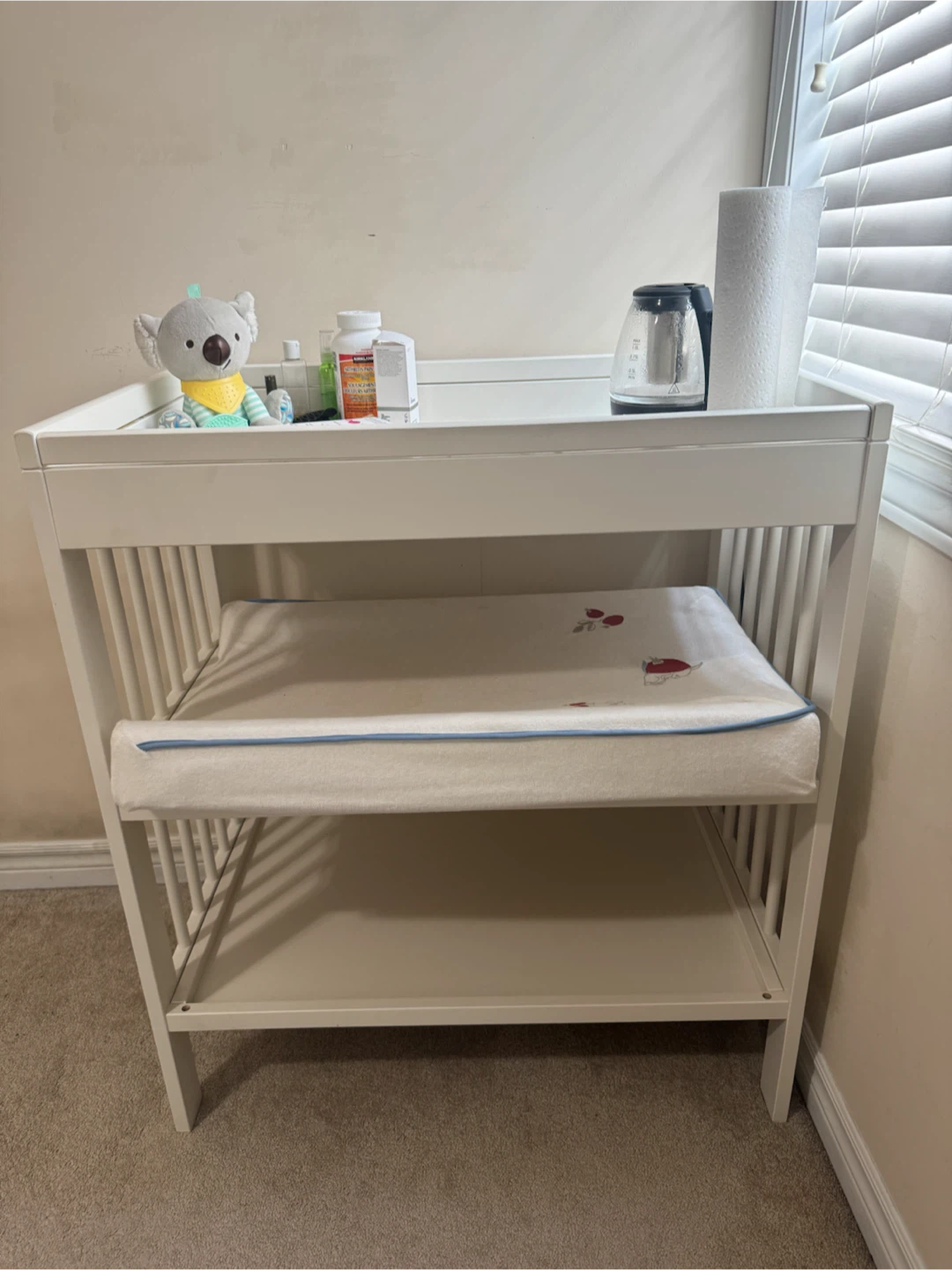 White wooden baby changing table with mat