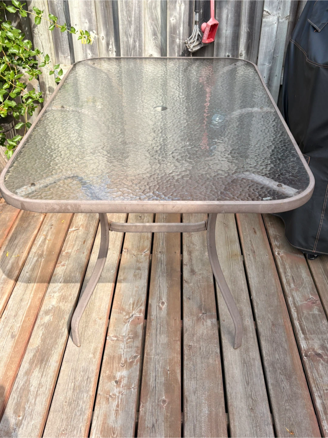 Glass top patio table with umbrella hole