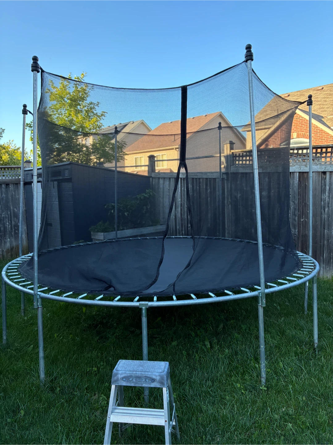 Large round outdoor trampoline with safety enclosure