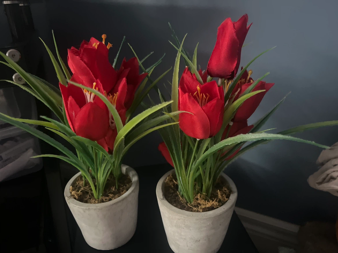 Two artificial red tulips in grey pots