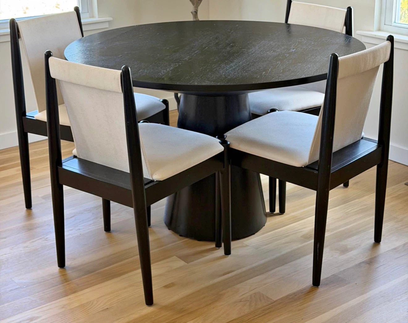 Round Black Dining Table with Four Cream Chairs