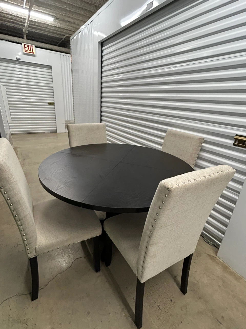 Round Black Dining Table with 4 Beige Upholstered Chairs