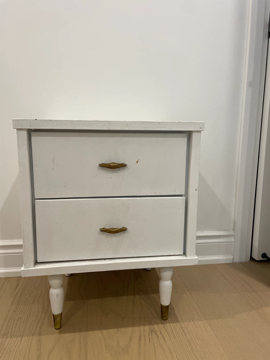 White two-drawer nightstand with gold accents