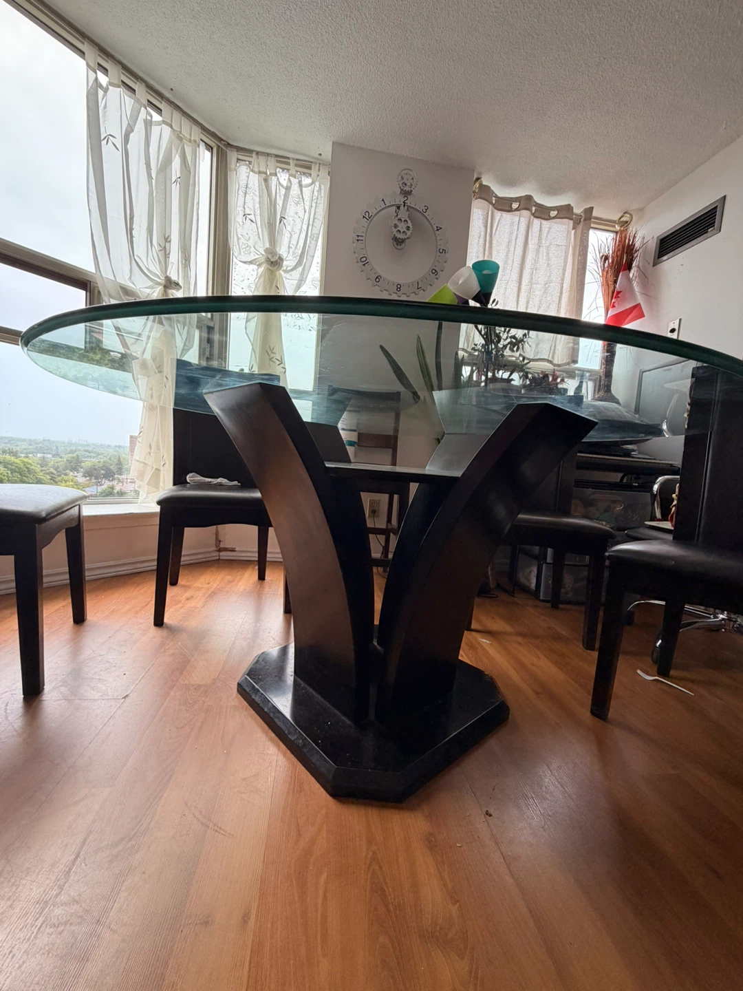 Round glass dining table with four black chairs