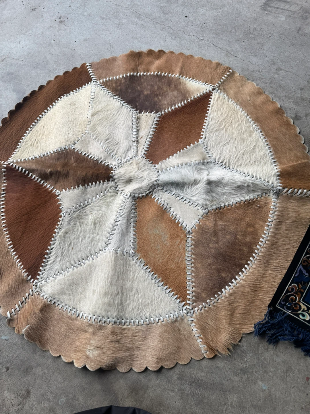 Round cowhide patchwork rug and bullfighter tapestry