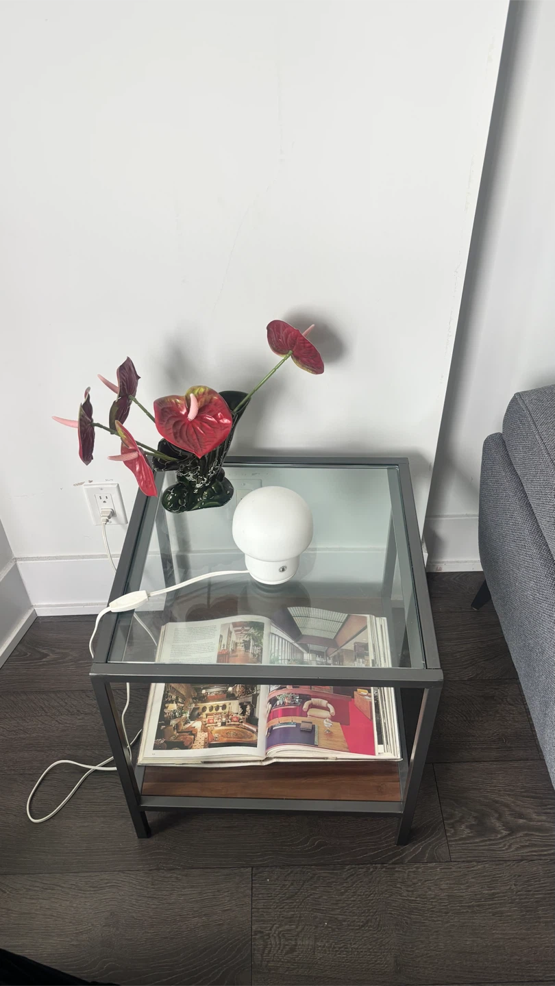Glass side table with a brown wooden base shelf