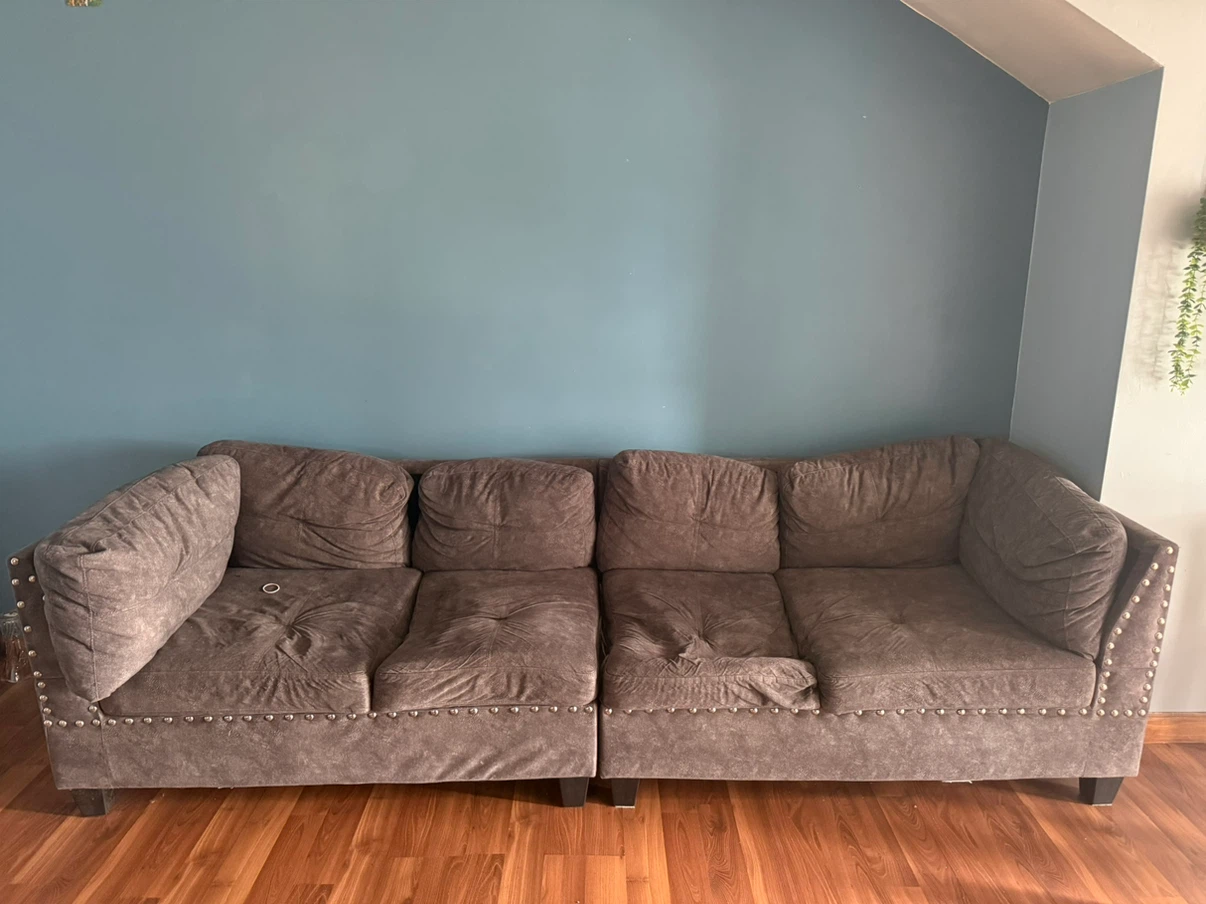 Grey four seater sofa with nailhead trim