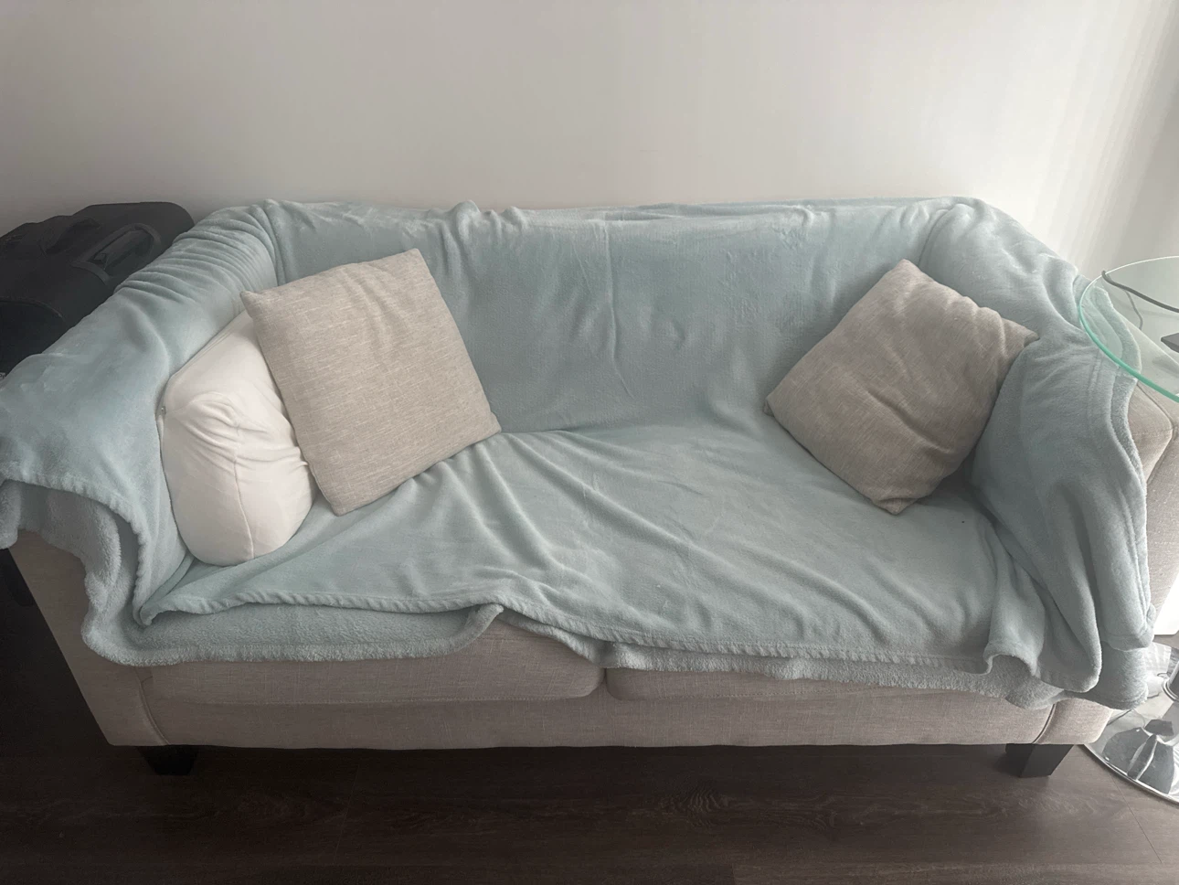 Light grey two seater sofa with light blue throw