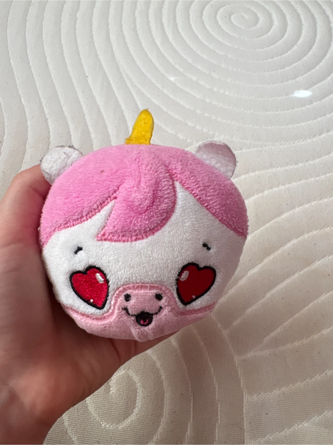 Plush toy with unicorn horn and heart eyes