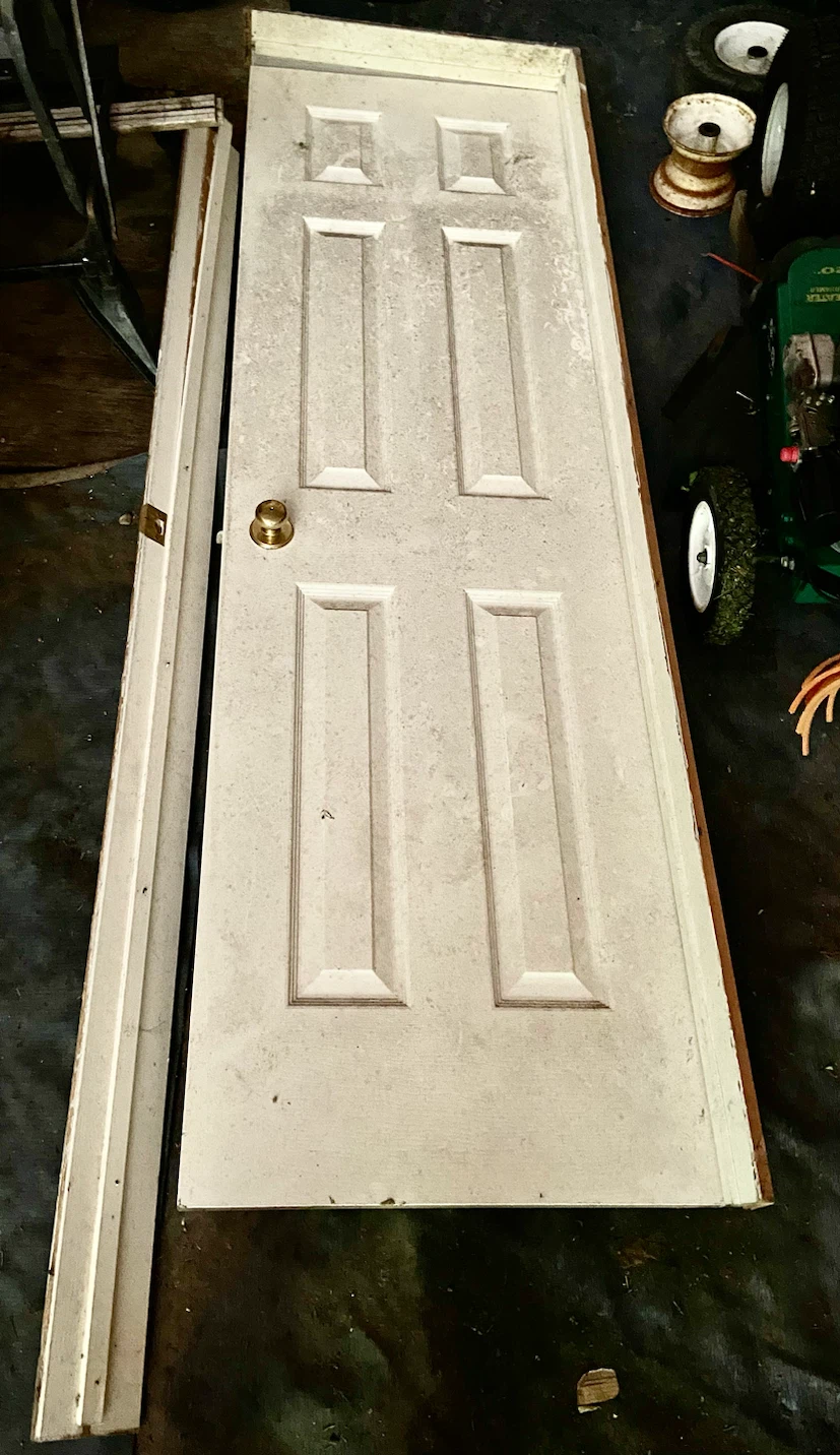 White six-panel interior door with brass hardware