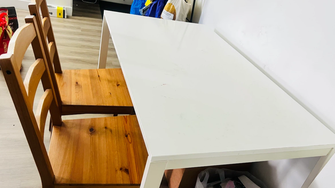 IKEA table along with two wooden chairs