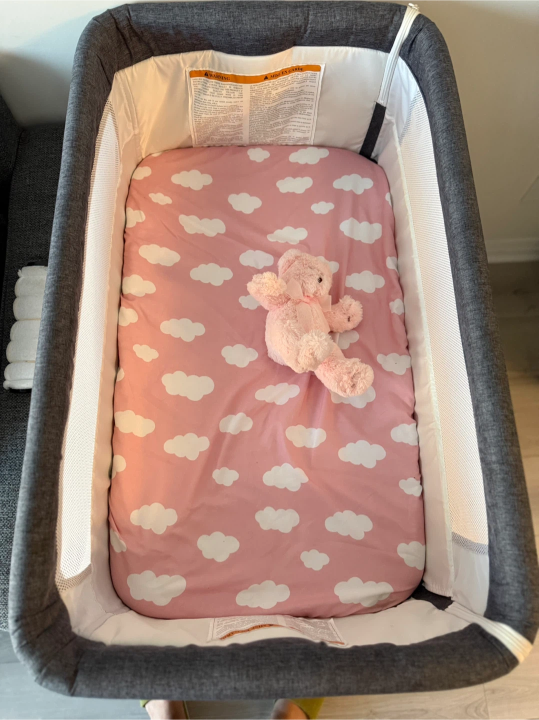 Grey bedside bassinet with storage basket