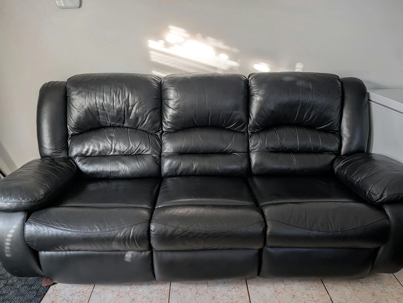 Black leather three seater sofa