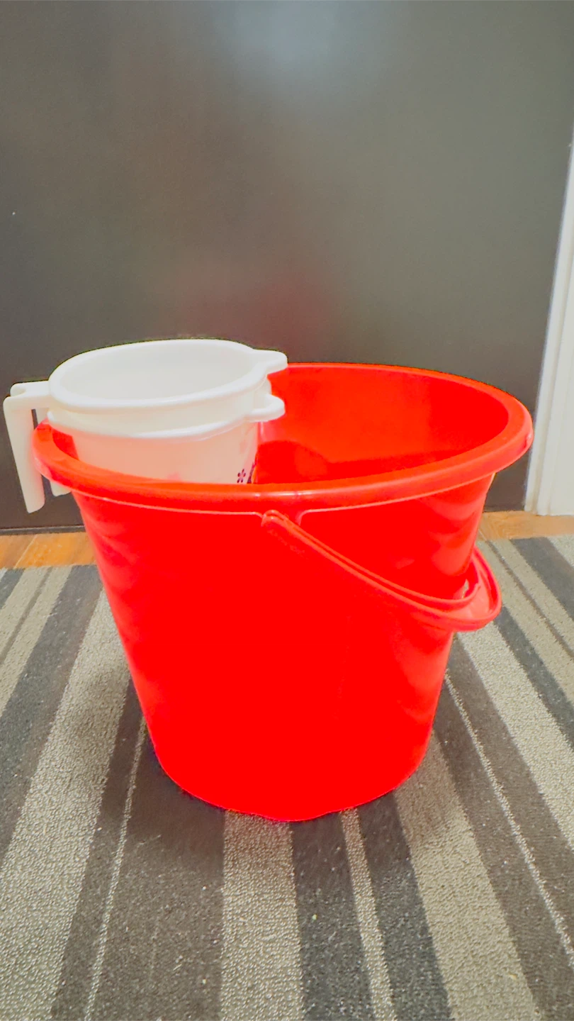 Red bucket with white mugs or  strainer