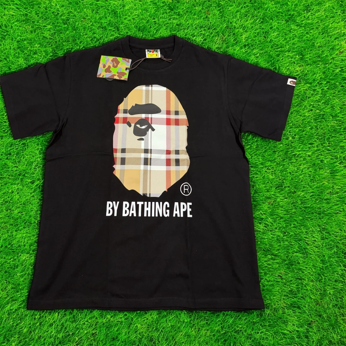 A 100% cotton T-Shirt featuring a Bape logo.