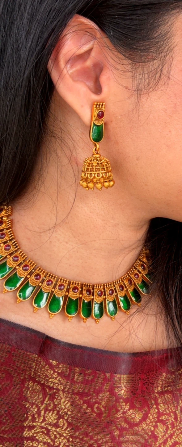 Gold necklace and earrings set with green enamel and red stones
