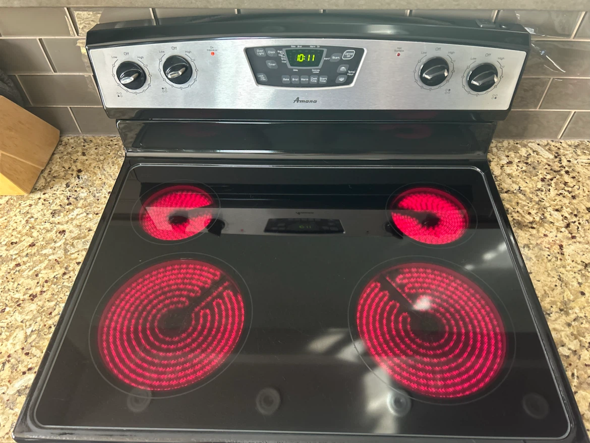 Stainless steel Amana electric range with a black glass cooktop