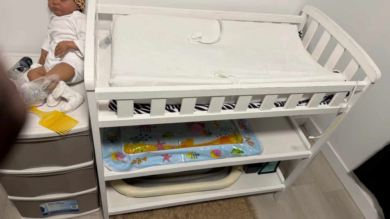 White wooden changing table with storage shelves