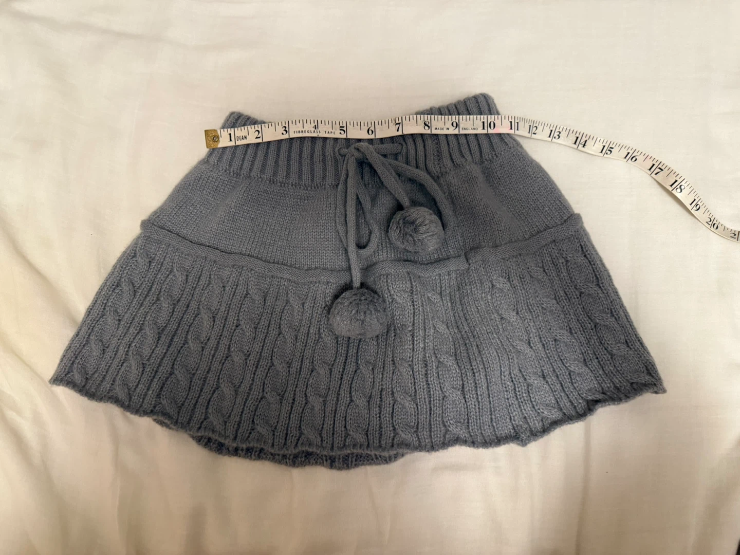 Grey knit mini skirt with pom pom ribbon detail