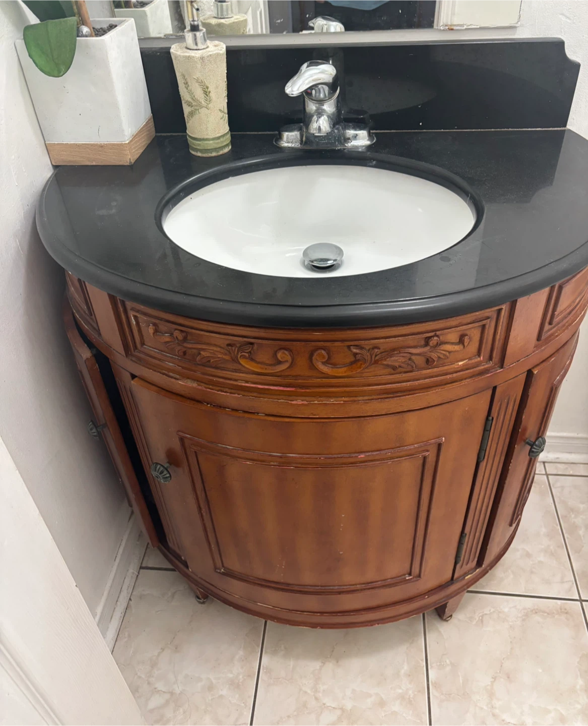 Curved Vanity Cabinet with Black Countertop and Sink