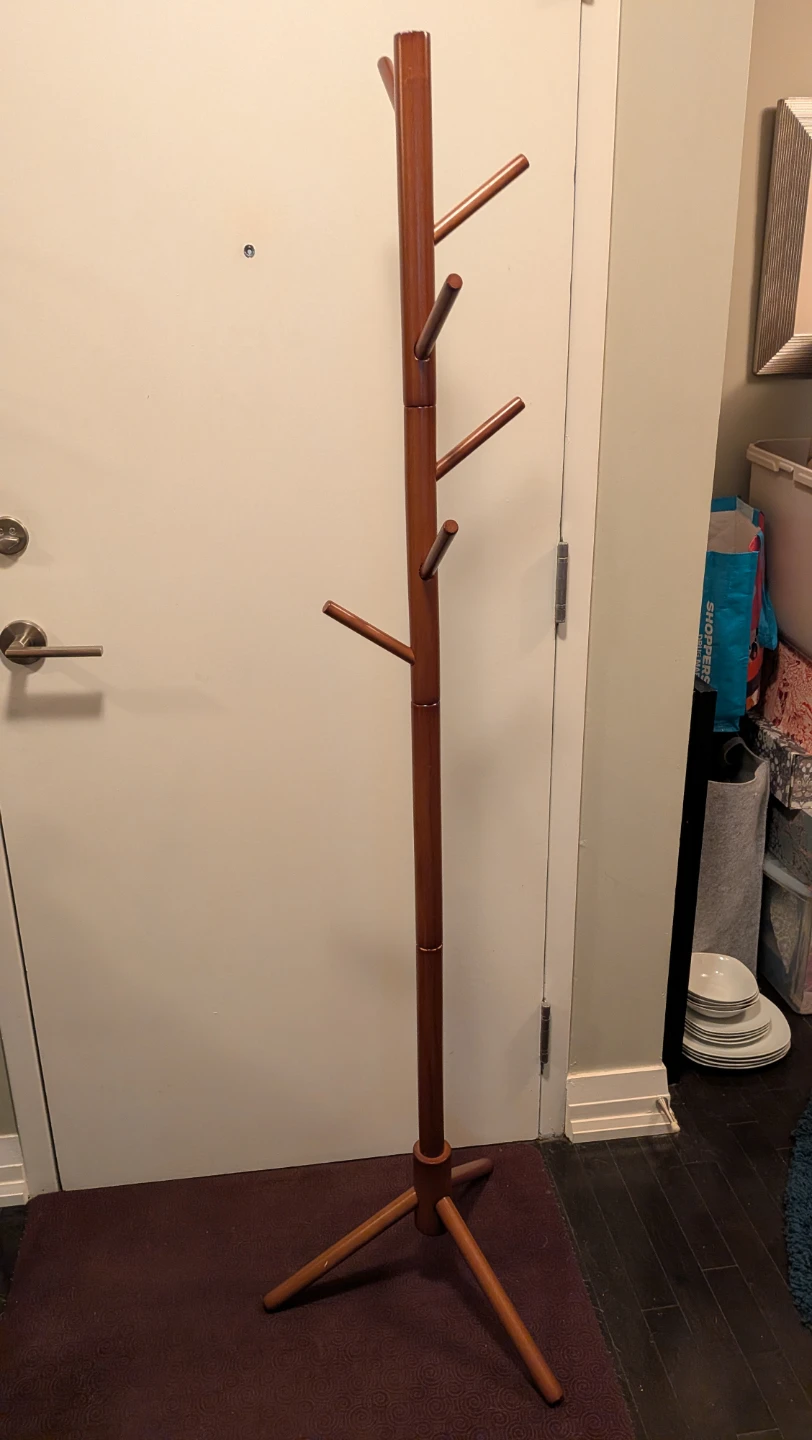 Wooden standing coat rack in reddish brown
