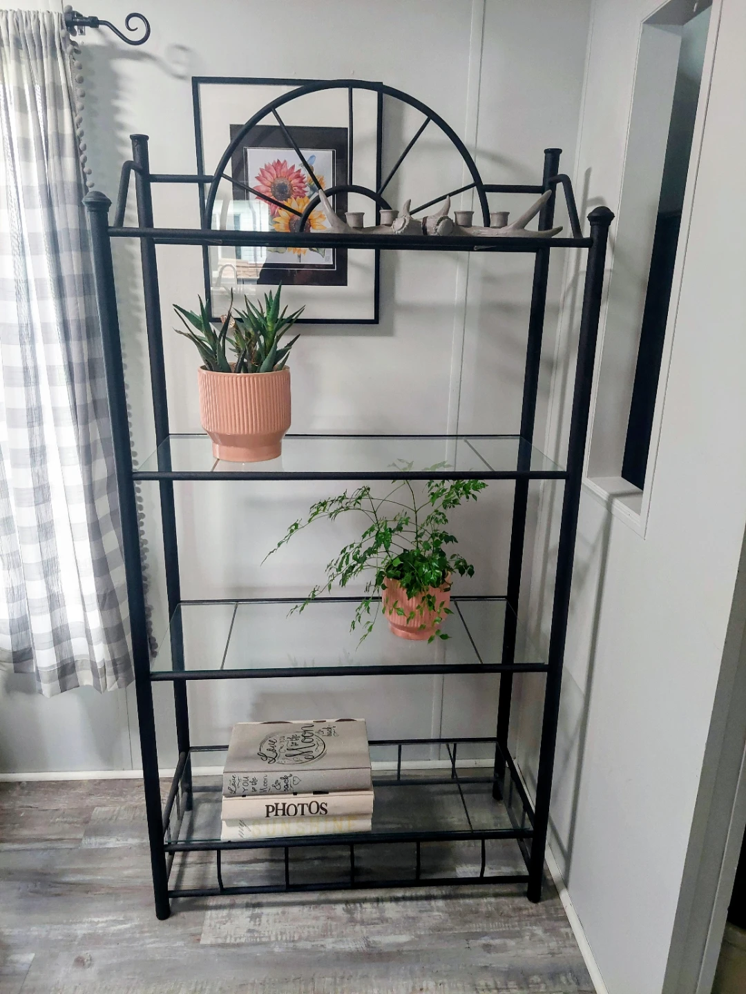 Black metal shelf unit with glass shelves