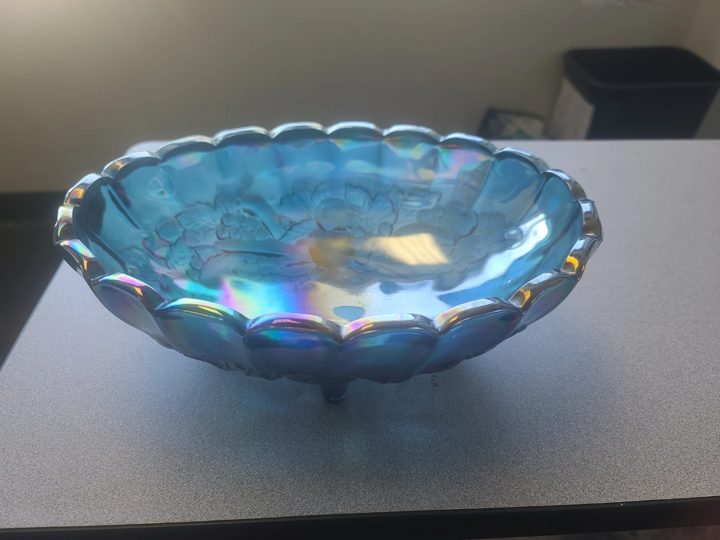 Blue iridescent glass footed bowl with grape and leaf design
