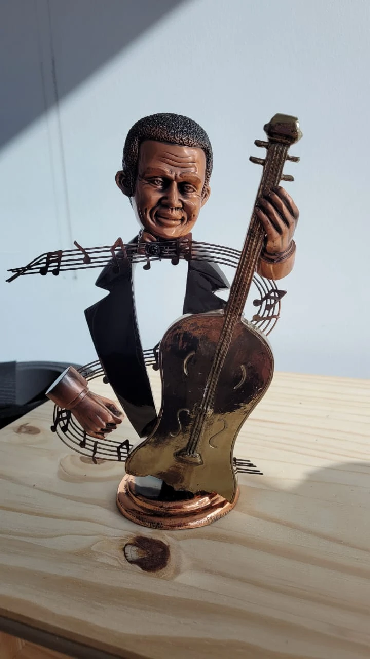 Figurine of a jazz musician playing a cello with musical notes