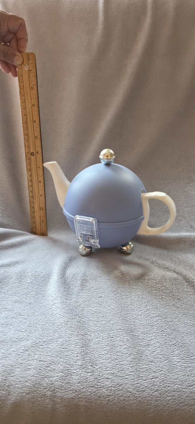 White ceramic teapot with blue insulated cozy