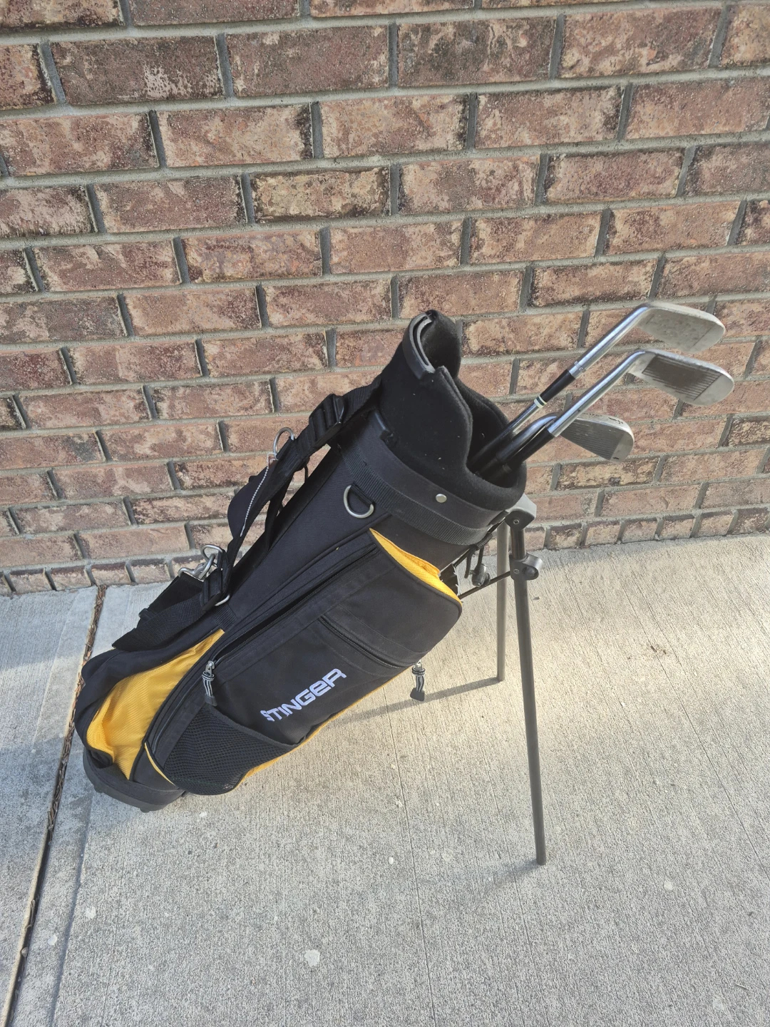 Youth Black and Yellow Golf Bag With Some Irons