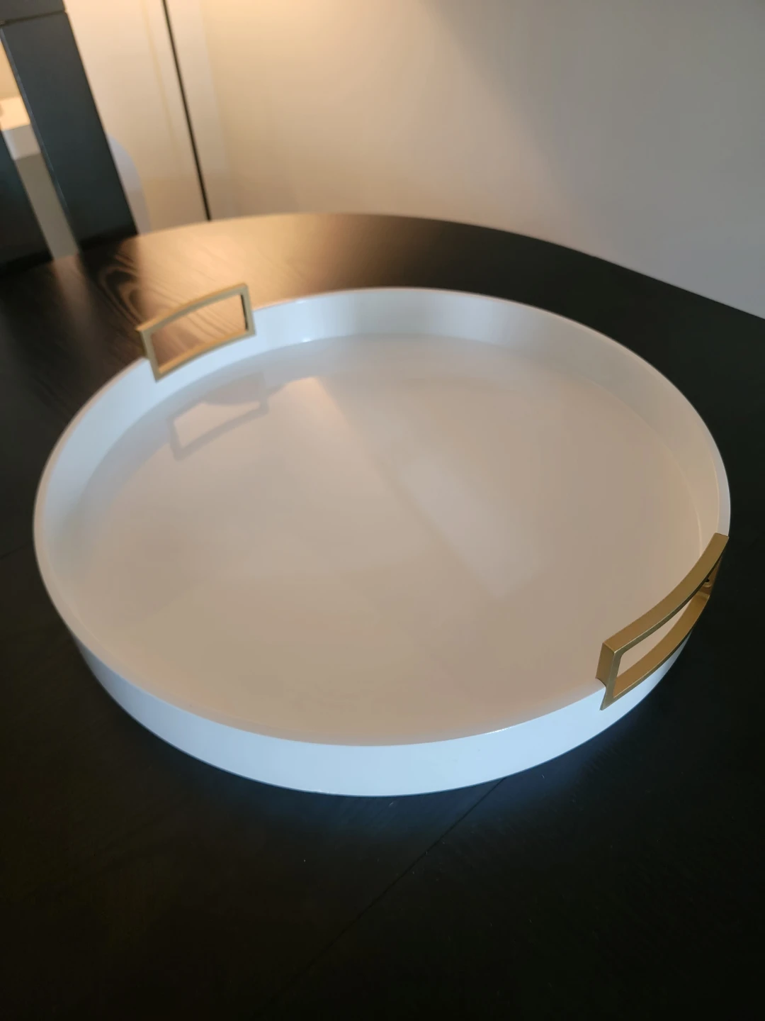 White circular serving tray with gold handles