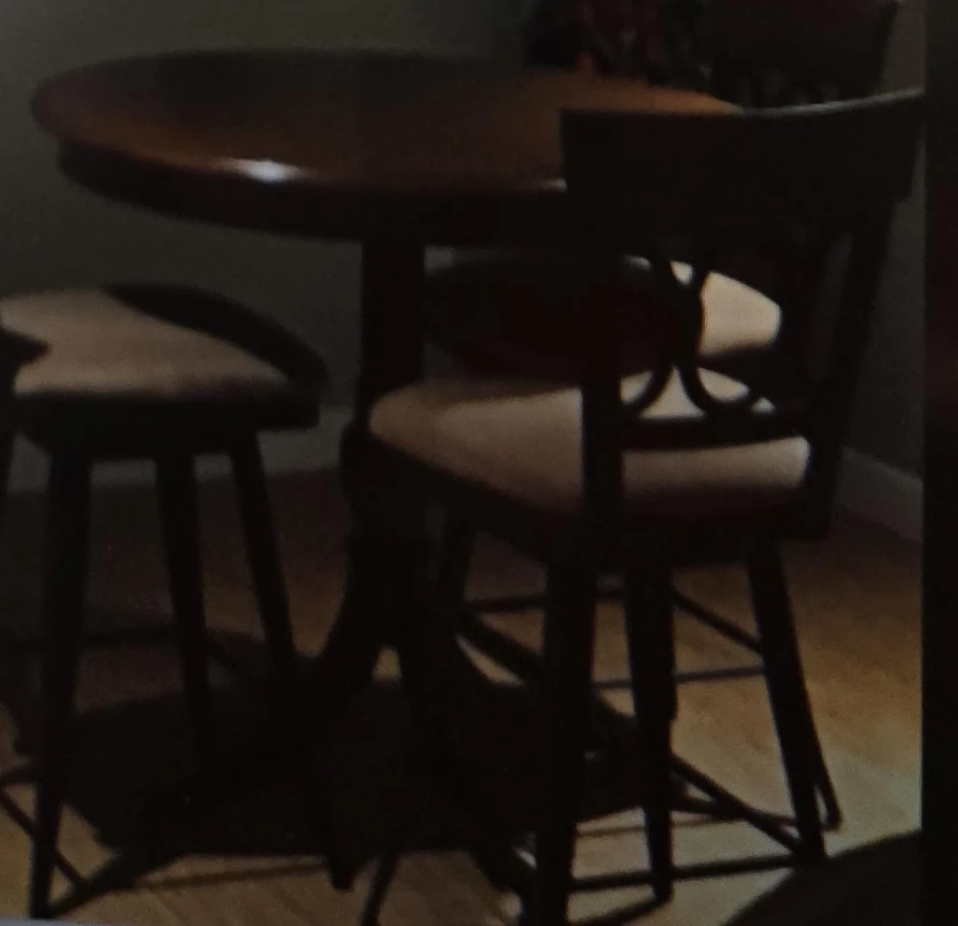 Round wood table with three swivel chairs