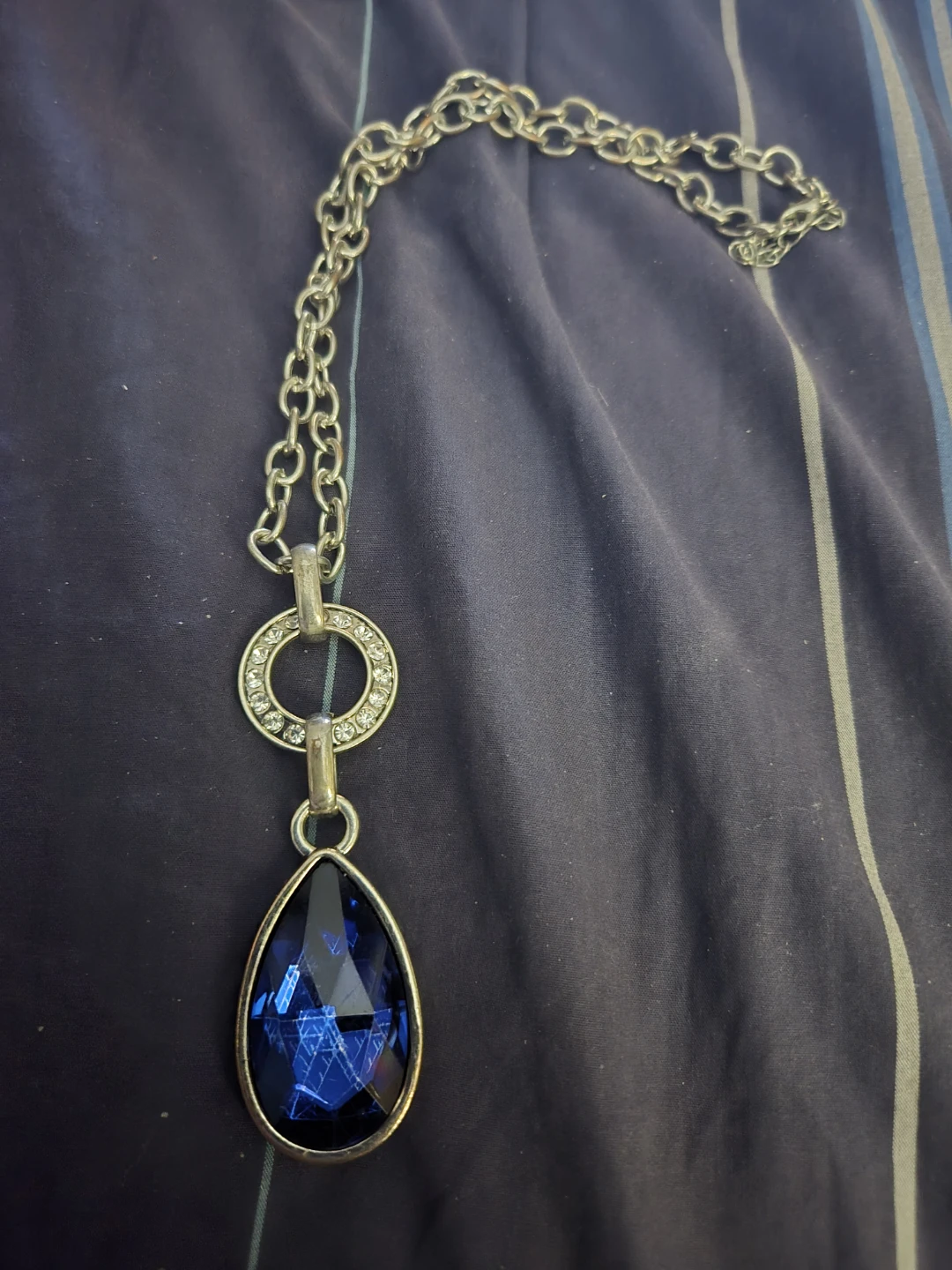Silver-tone necklace with blue teardrop pendant