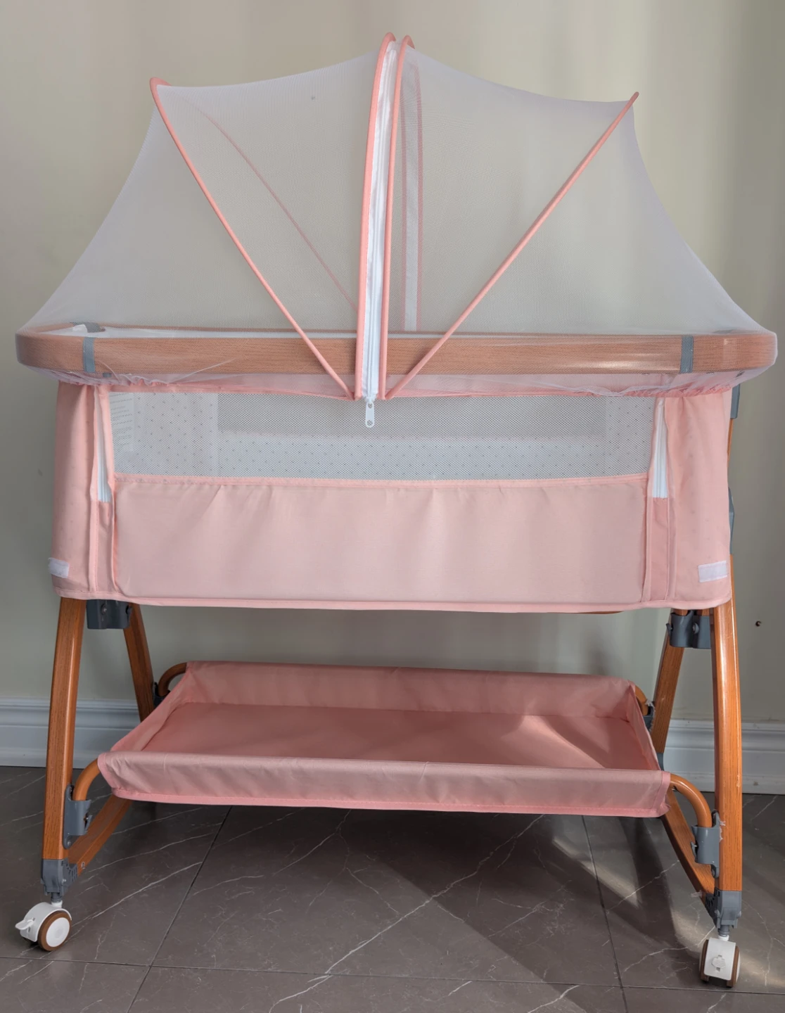 Pink baby bassinet with mosquito net
