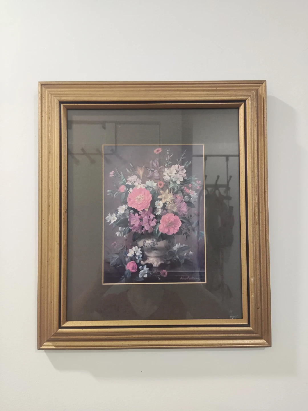 Picture of a flower painting on a gold frame.