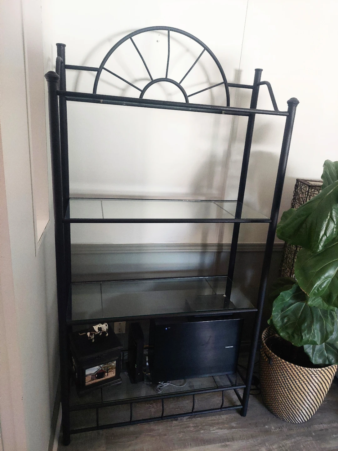 Black metal shelf unit with glass shelves