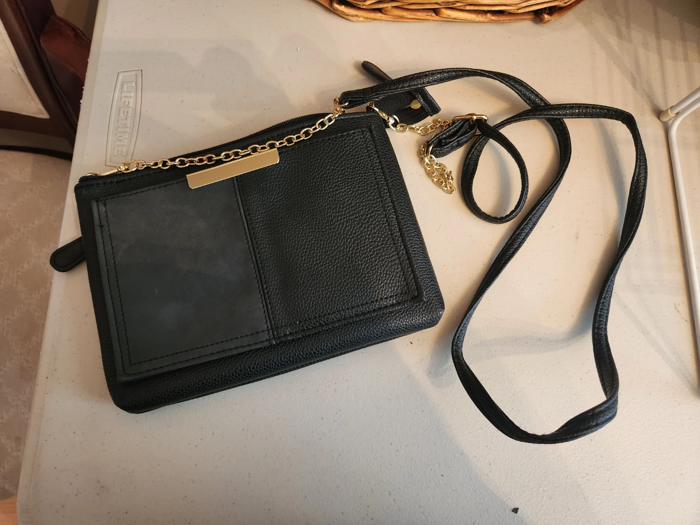 Black crossbody bag with gold chain detail