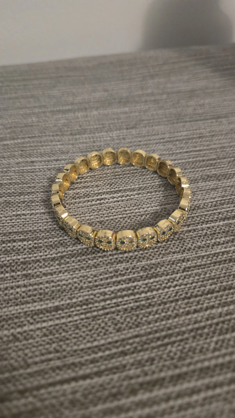 Gold-tone smiley face bracelet with green gems