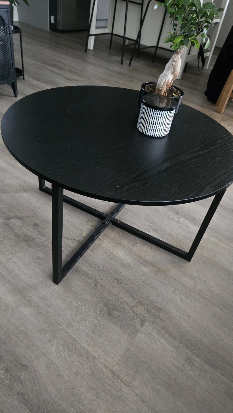 Round coffee table with black wood top and metal base