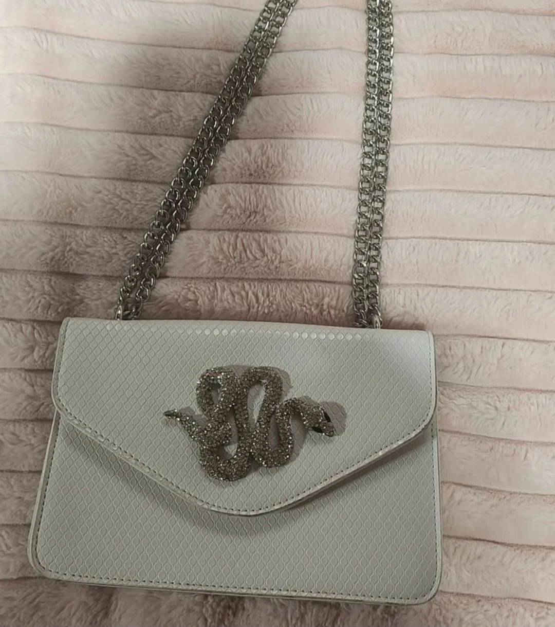 White crossbody bag with rhinestone snake embellishment