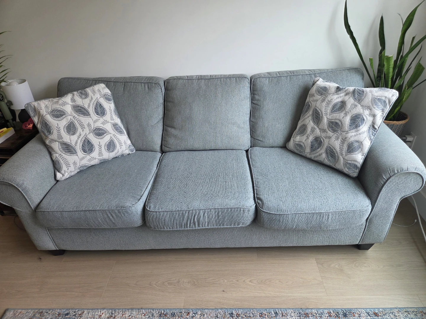 Light Blue Three-Seater Sofa with Decorative Pillows