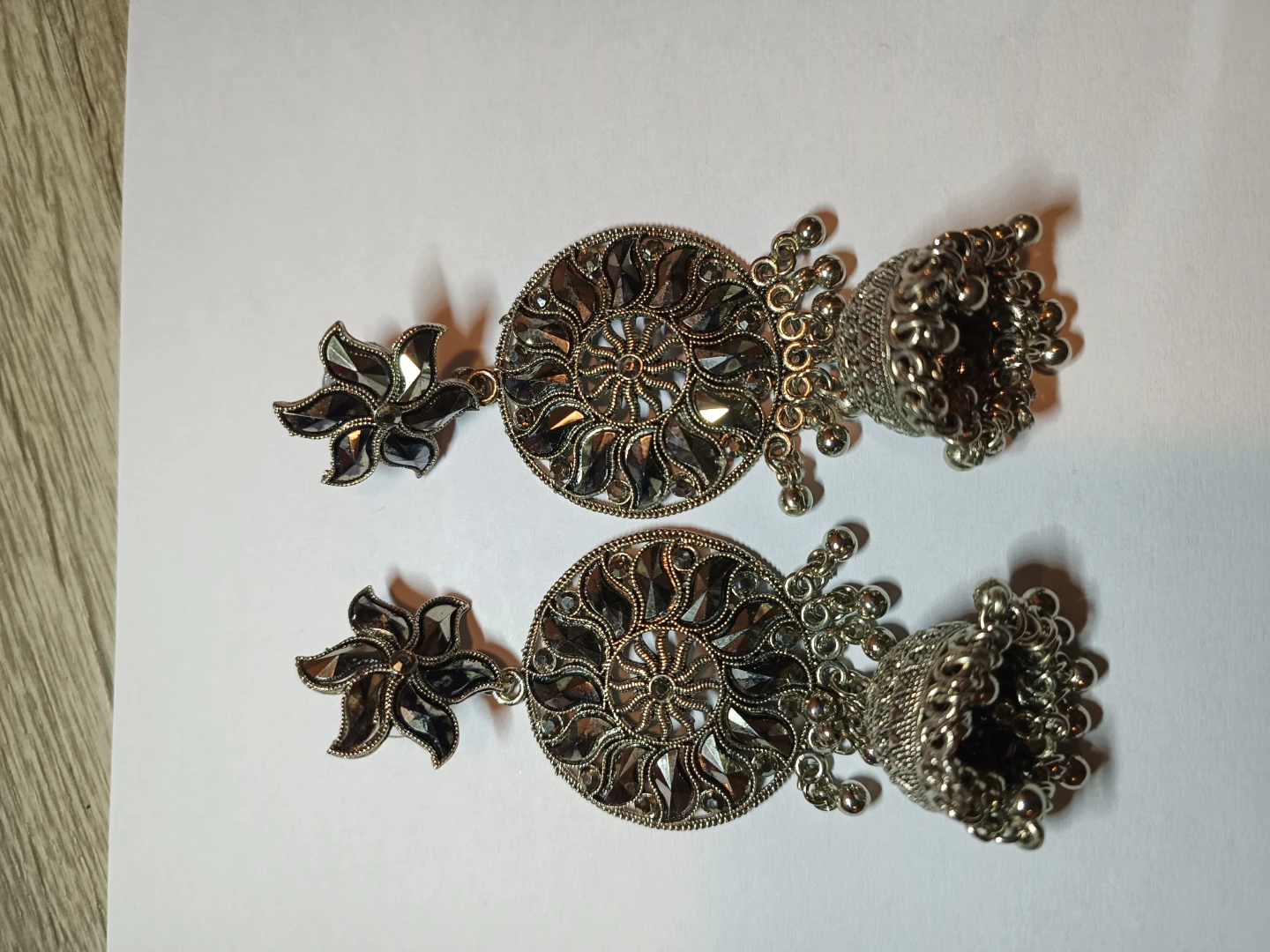 Silver tone jhumka earrings with floral detail