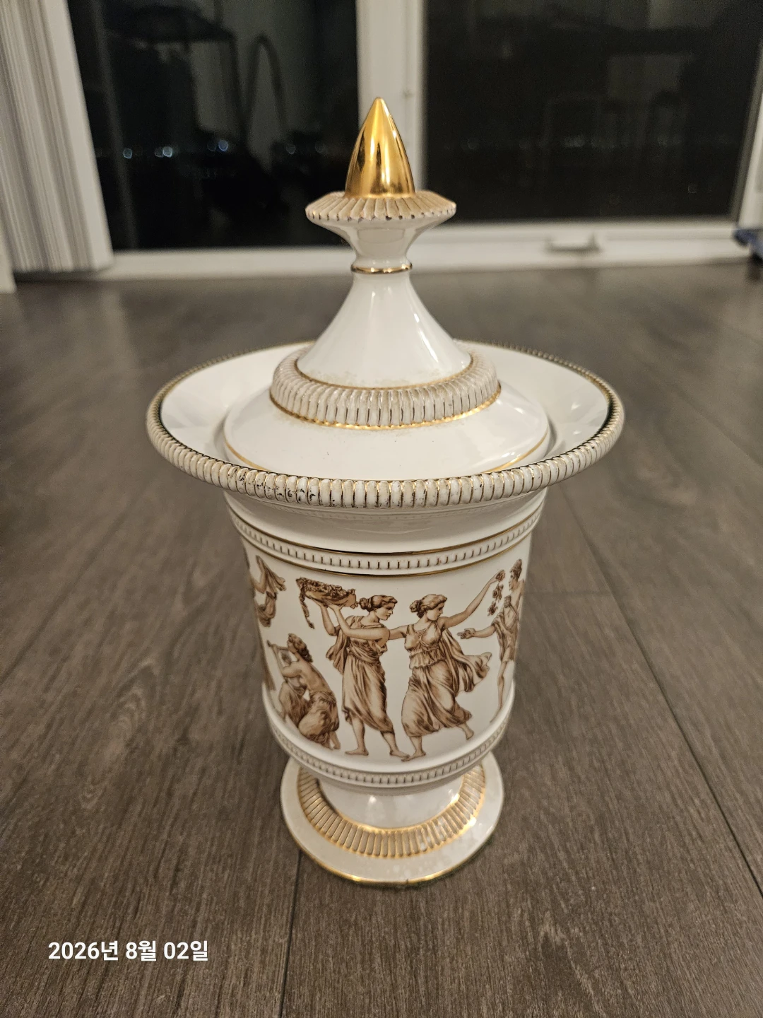 White Ceramic Urn with Gold Trim and Classical Figures