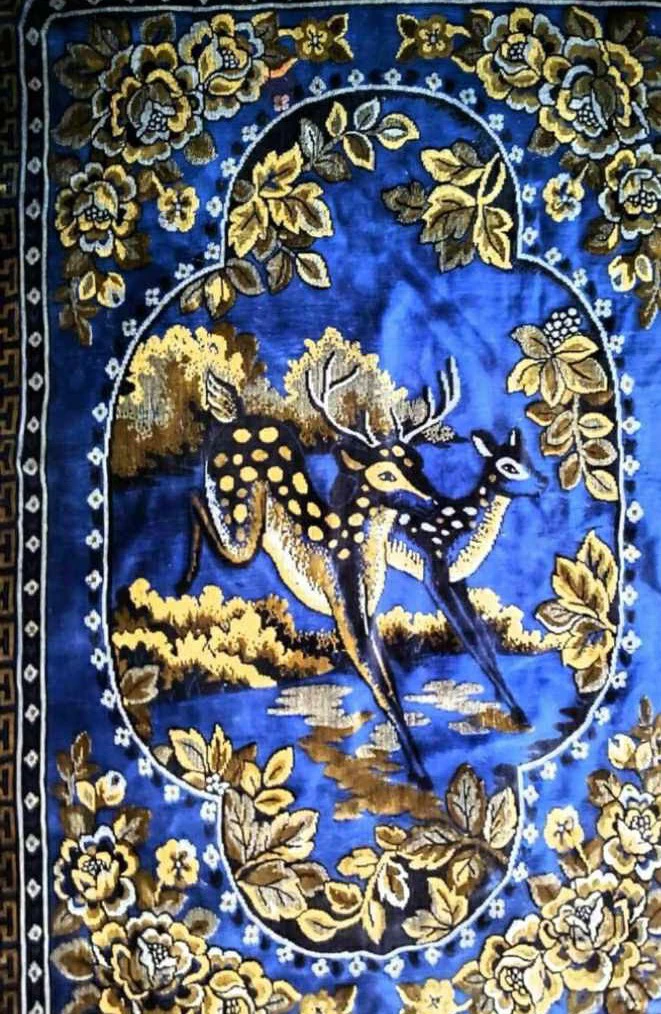 Blue rug with deer and floral design