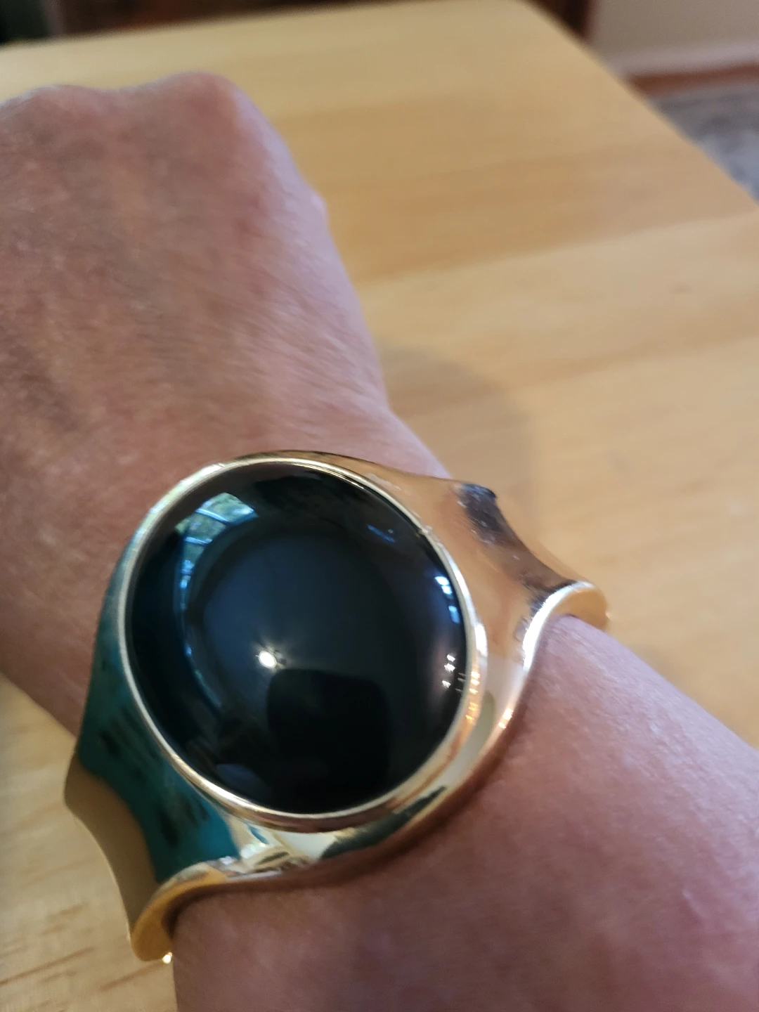 Gold tone cuff bracelet with black stone accent