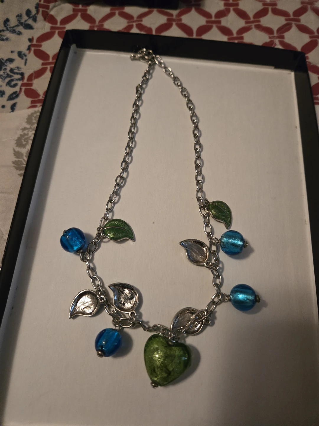 Silver-tone necklace with blue beads and green heart pendant