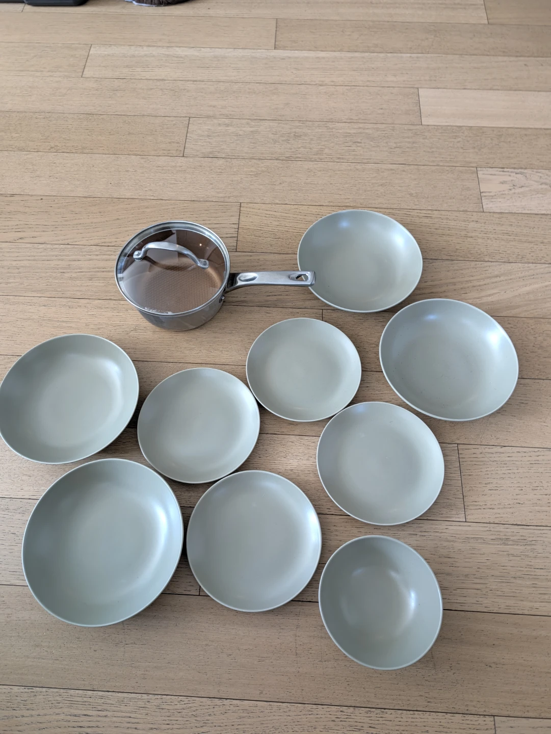 Kitchenware set with saucepan and sage green ceramic dishes