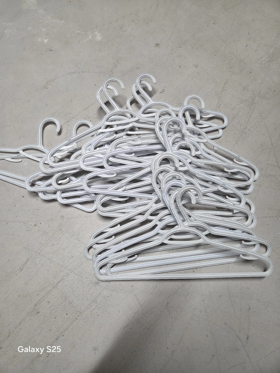 Pile of White Plastic Hangers - photo 3