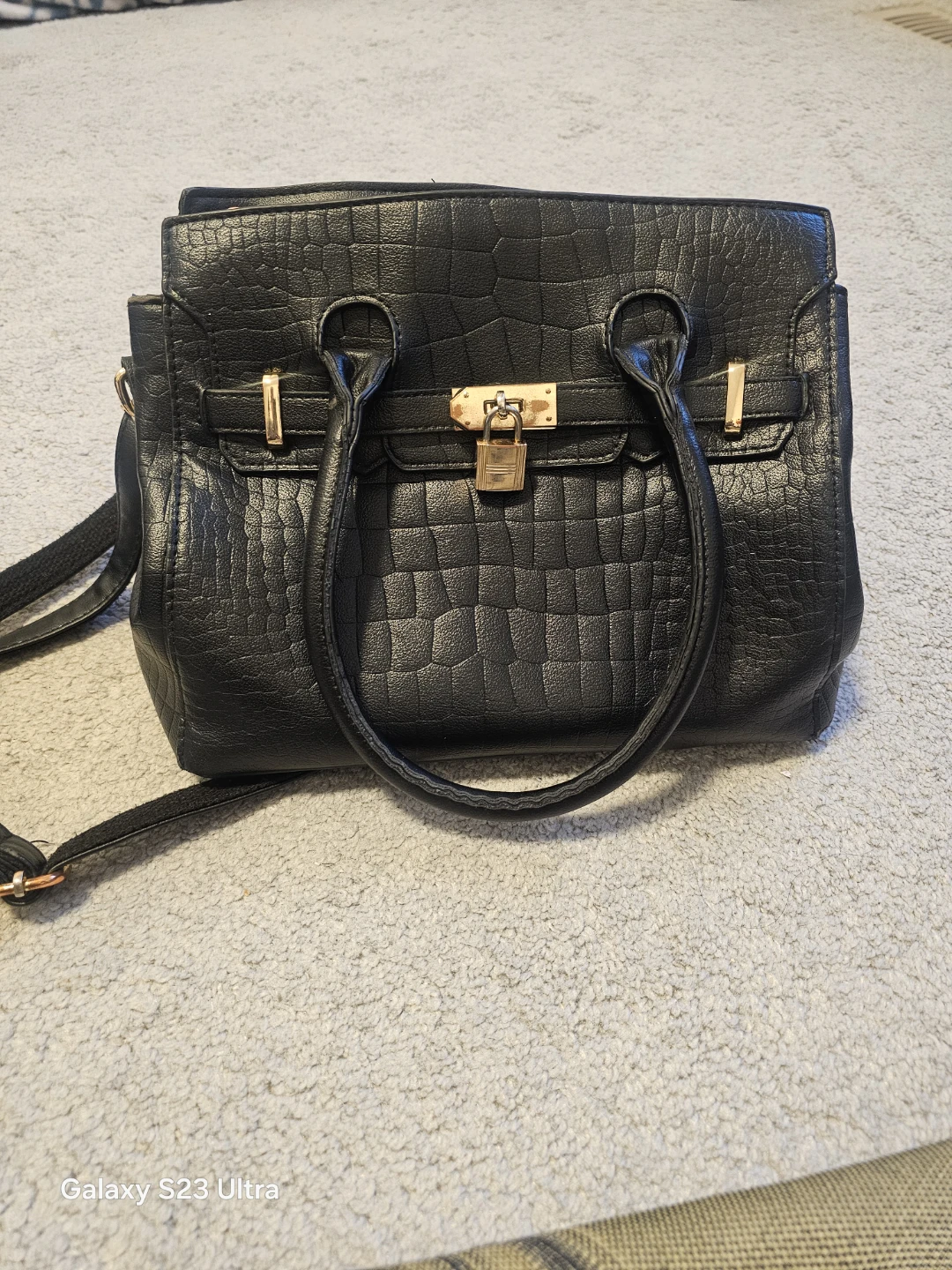 Black textured handbag with gold lock detail